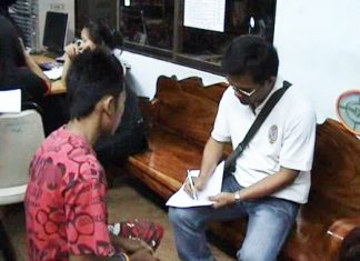 Thanakorn Putaka, left, gives a statement to Pattaya police.